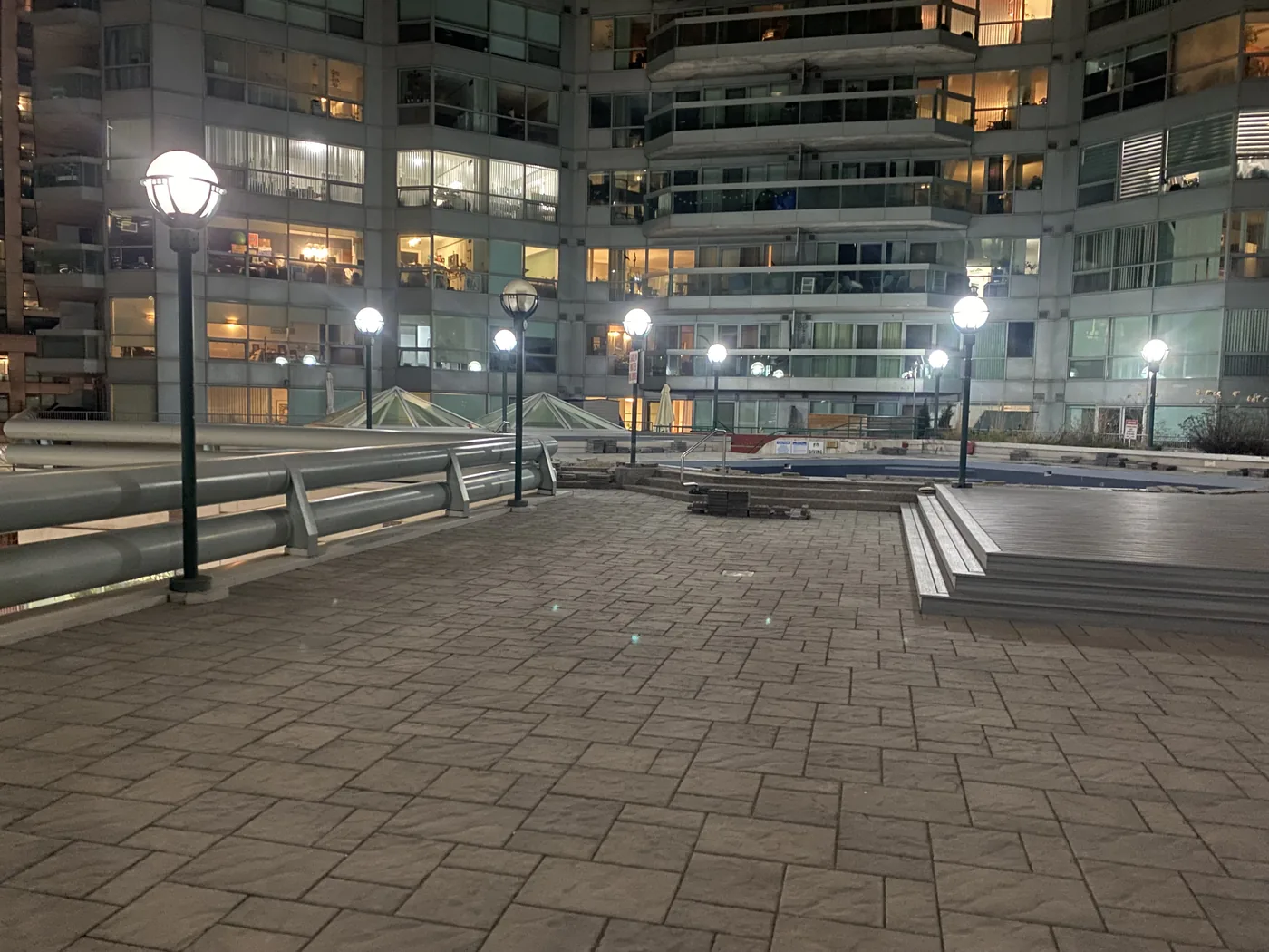 Condo courtyard at night with pole and globe exterior lighting fully lit after maintenance
