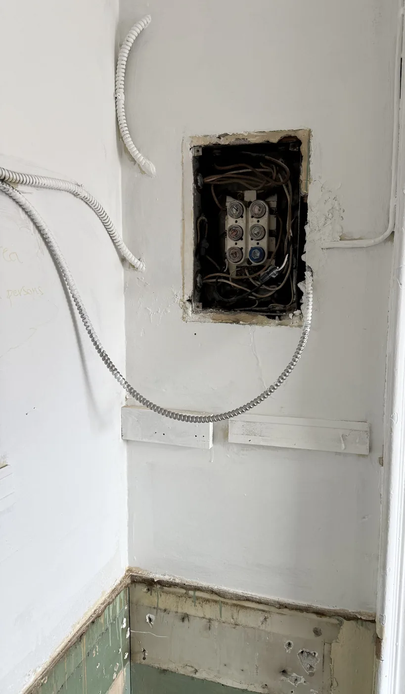 Old panel removed from the wall during an electrical service upgrade
