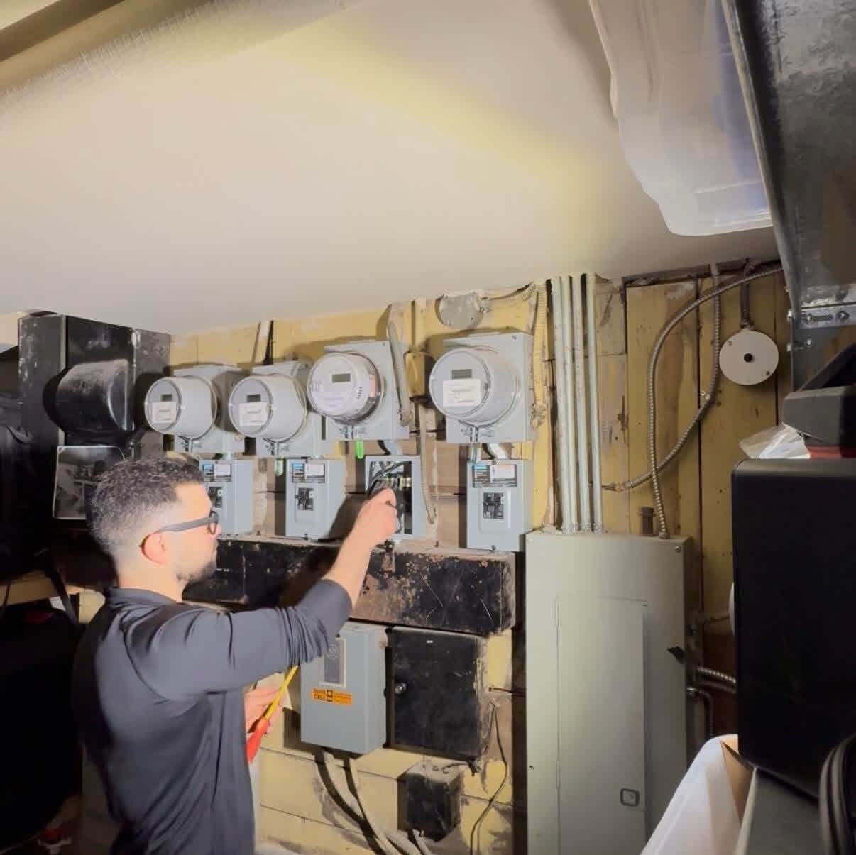 Portman Electric electrician servicing a multi-unit meter bank and electrical panels