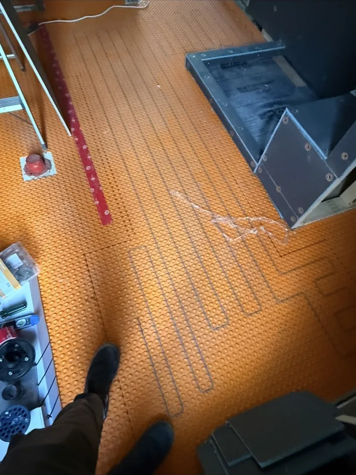 Electric heated floor wiring installed before the finished floor assembly in a Toronto renovation.