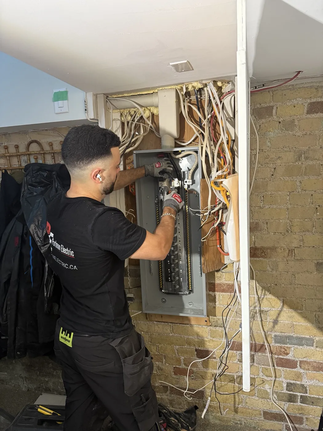 Electrician replacing a damaged electrical panel in a Riverdale Toronto home.