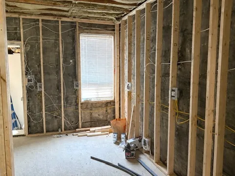 Electrical rough-in during a Toronto renovation — new wiring run through open stud framing to mounted device boxes before drywall