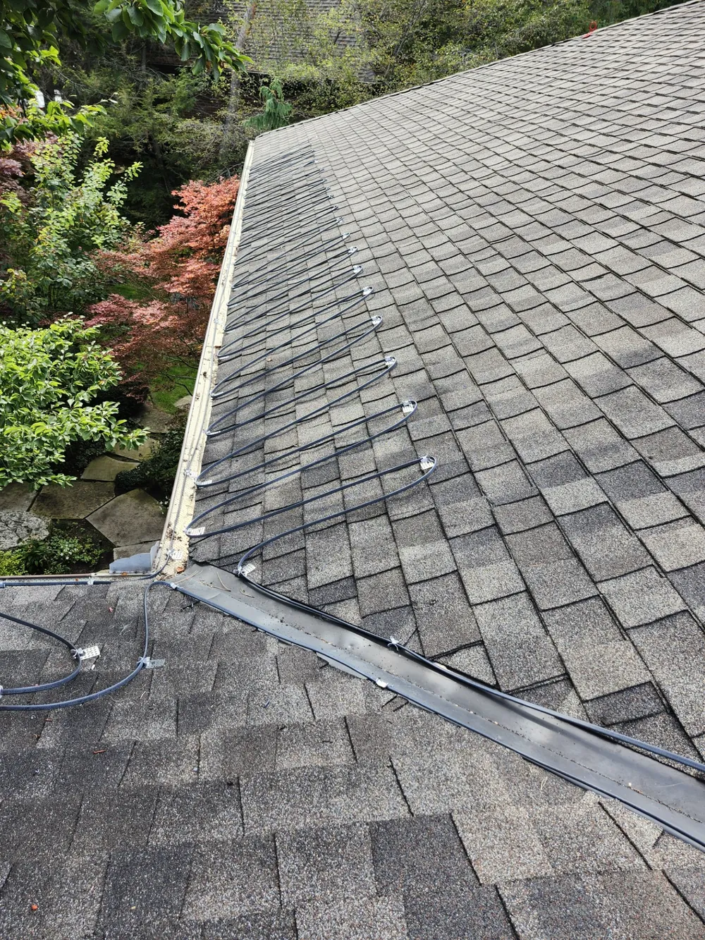 De-icing heat trace cable installed in a zigzag pattern along a shingled roof edge in Toronto