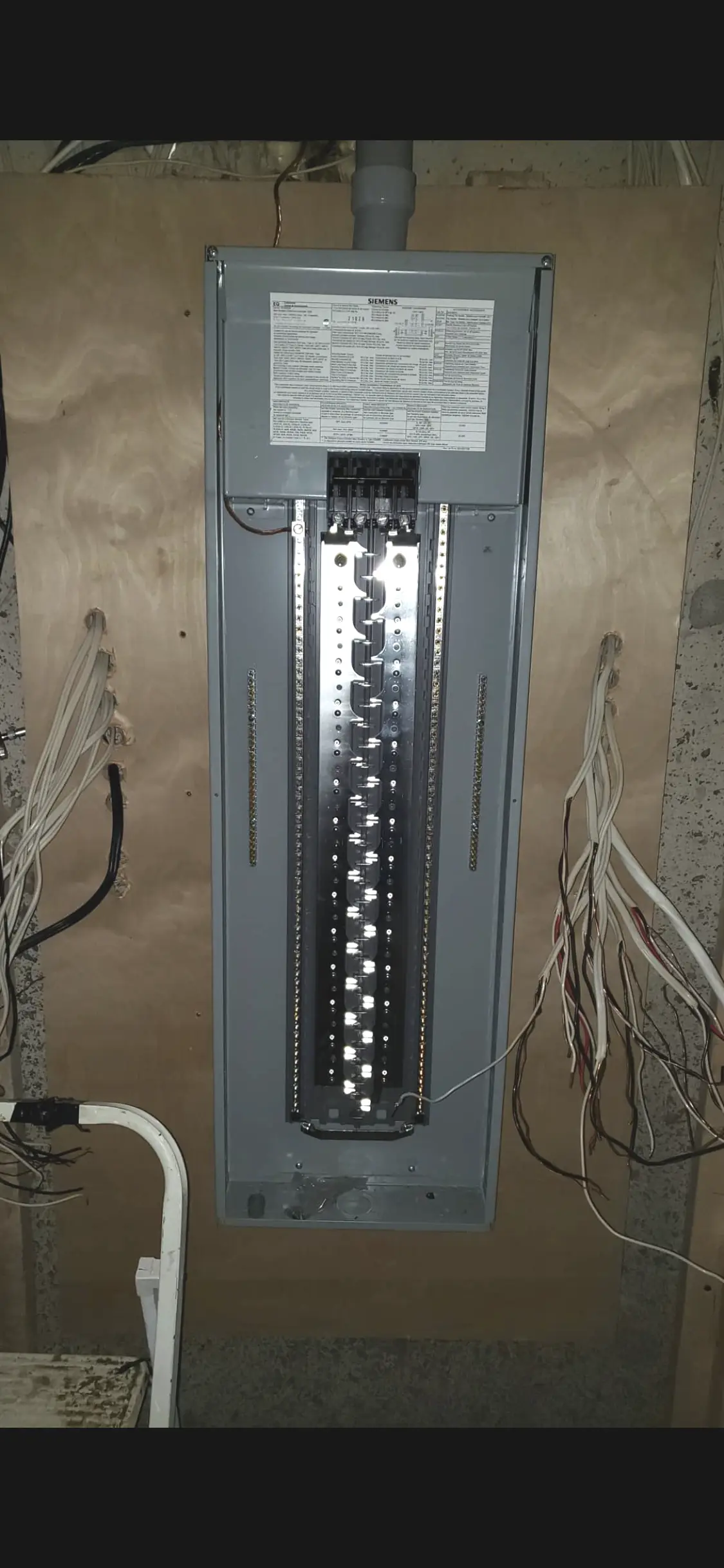 Siemens electrical panel during installation with the cabinet mounted and interior bus exposed before breakers go in